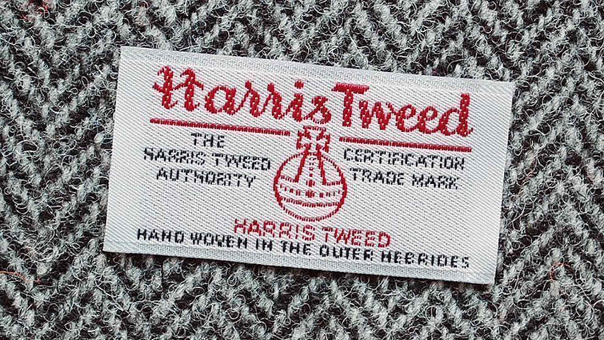 xuits -Harris Tweed Etikett auf grauem Wollstoff mit Fischgrätmuster, handgefertigt Äußere Hebriden.