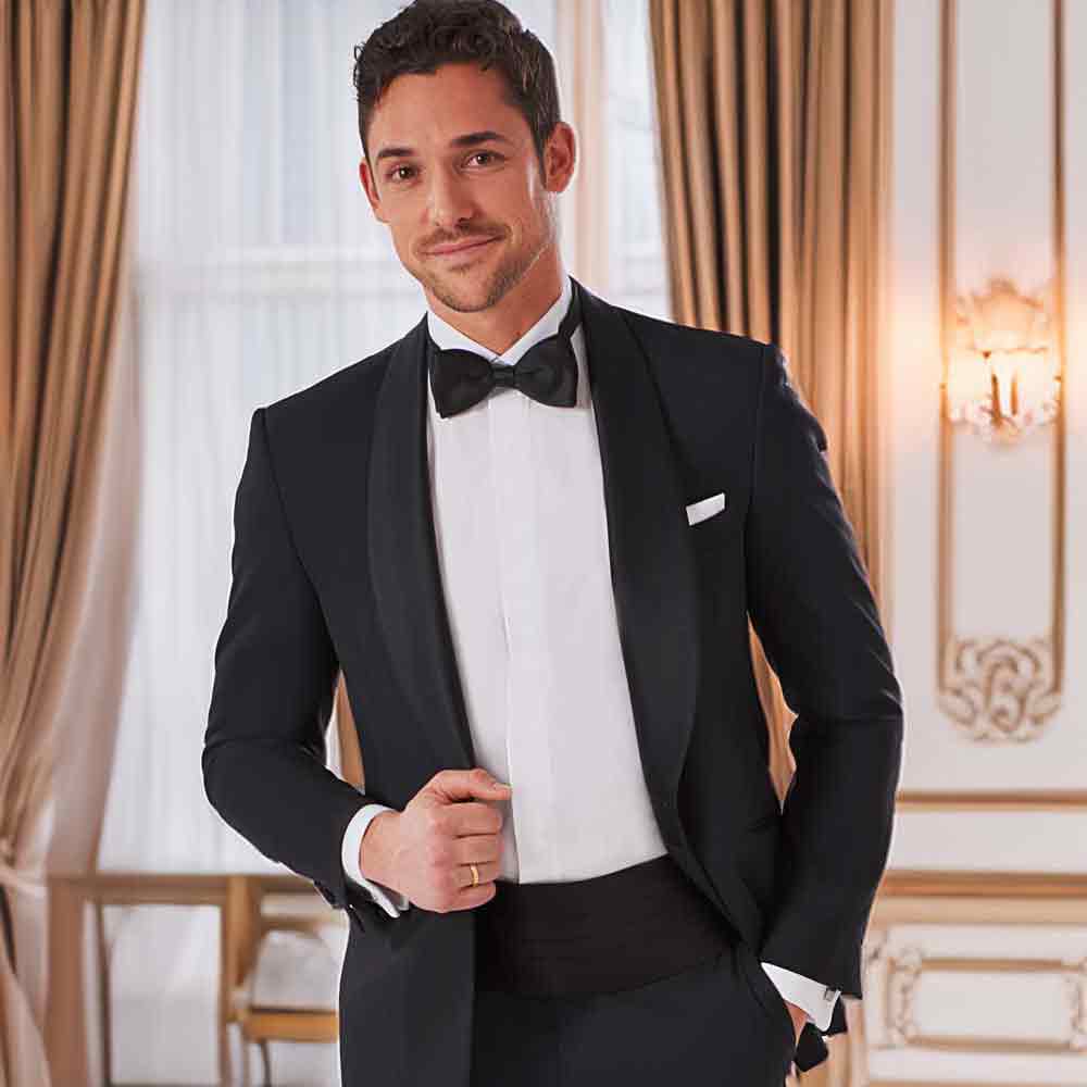 xuits-Mann in schwarzem Smoking mit Fliege in elegantem Raum mit Vorhängen und Wandverzierungen.